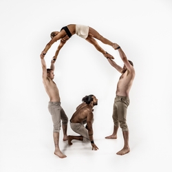 acrobats holding another acrobat in a backbend